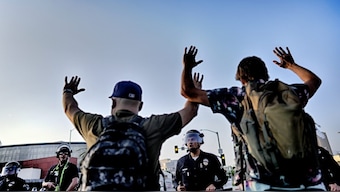 Los Angeles police officers with batons and riot gear attempt to move back protesters in downtown Los Angeles. AP