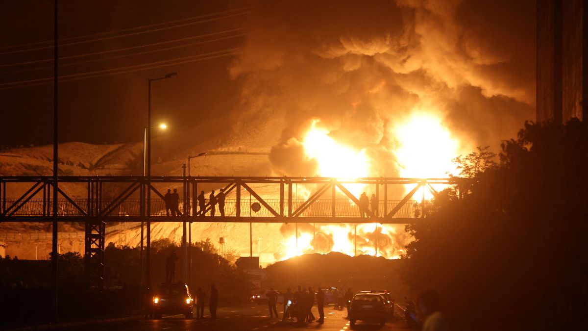 People watch from a bridge as flames from an Israeli attack rise from Sharan Oil depot, following Israeli strikes on Iran, in Tehran, Iran, June 15, 2025. Reuters People watch from a bridge as flames from an Israeli attack rise from Sharan Oil depot, following Israeli strikes on Iran, in Tehran, Iran, June 15, 2025. Reuters