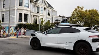 People take pictures of a Waymo driverless taxi passing by in San Francisco, California, U.S., September 28, 2024. (Reuters/Laure Andrillon)