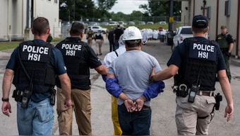 The photograph shows special agents with Homeland Security Investigations leading a worker away from a workplace raid in Ohio in 2018, part of a string of such operations during the first Donald Trump administration. (Photo: Immigration and Customs Enforcement)/Representational