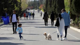 An Iranian child looks at the dog as he walks, in Tehran, Iran, March 30, 2021. File Image/WANA via Reuters