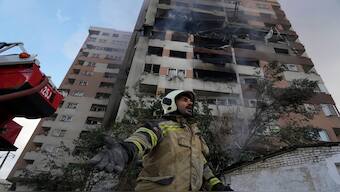 A firefighter calls out his colleagues at the scene of an explosion in a residence compound in northern Tehran, Iran, on Friday. AP