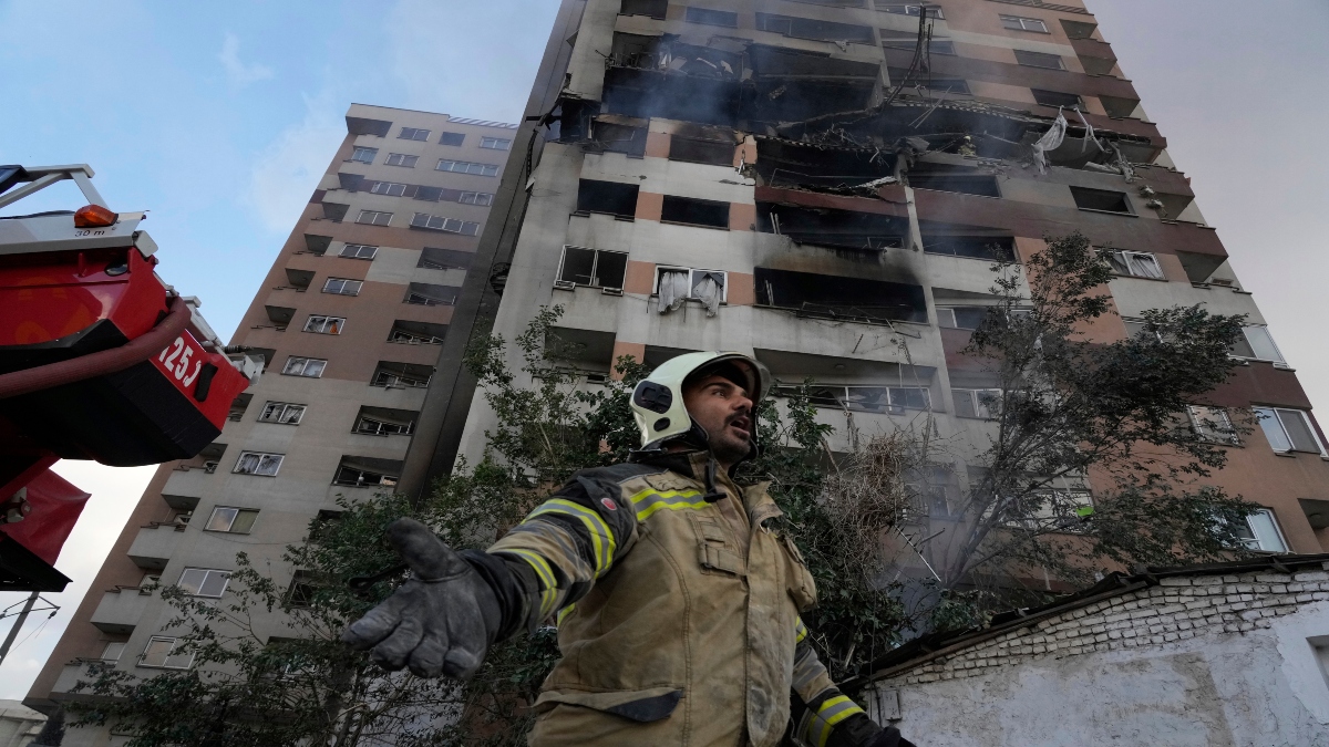 A firefighter calls out his colleagues at the scene of an explosion in a residence compound in northern Tehran, Iran, on Friday. AP A firefighter calls out his colleagues at the scene of an explosion in a residence compound in northern Tehran, Iran, on Friday. AP