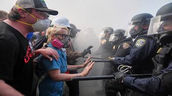 Protesters confront police on the 101 Freeway near the Metropolitan Detention Center of downtown Los Angeles, on Sunday, following last night's immigration raid protest. AP