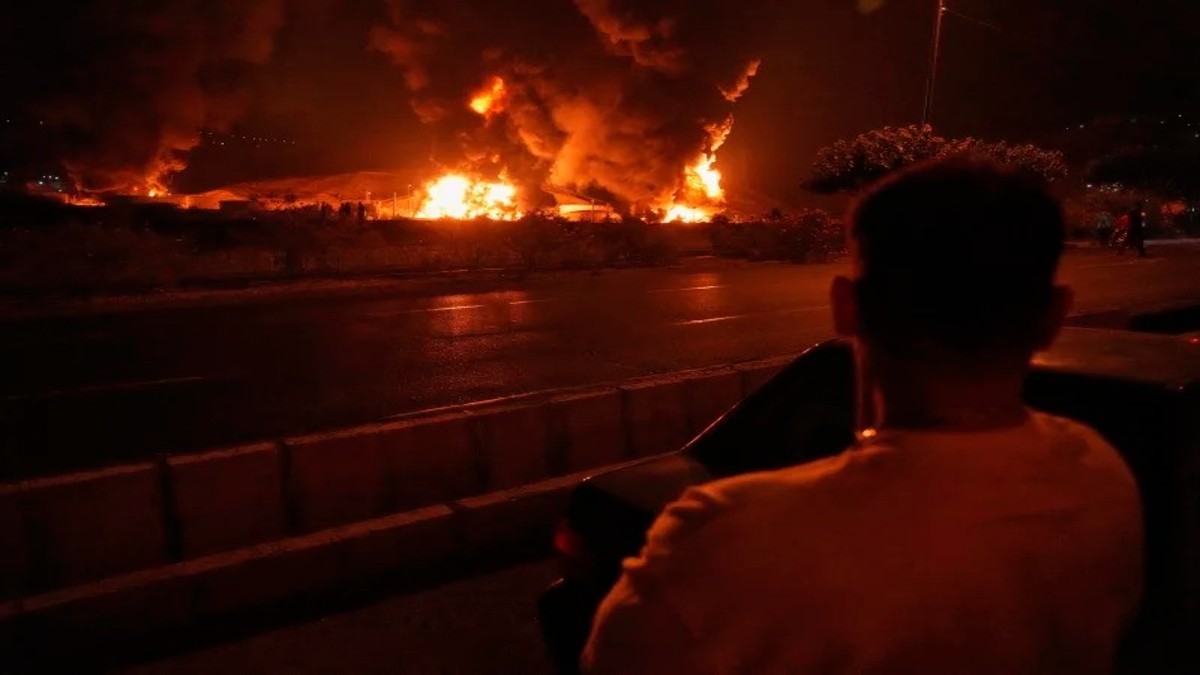 A man looks at flames rising from an oil storage facility after it appeared to have been struck by an Israeli strike in Tehran, Iran, early Sunday. Image: Vahid Salemi/AP A man looks at flames rising from an oil storage facility after it appeared to have been struck by an Israeli strike in Tehran, Iran, early Sunday. Image: Vahid Salemi/AP