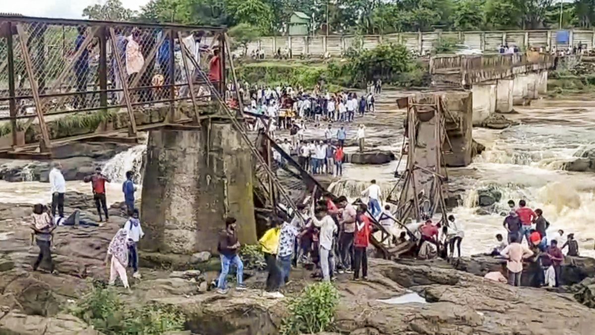 People stand near an iron bridge over the Indrayani river after it collapsed, in Pune district, Maharashtra. PTI People stand near an iron bridge over the Indrayani river after it collapsed, in Pune district, Maharashtra. PTI