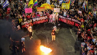 Demonstrators set fire to placards during an anti-government protest calling for action to secure the release of Israeli hostages held captive since the October 7, 2023 attacks by Palestinian militants, in front of the Defence Ministry in Tel Aviv on May 31, 2025. - AFP