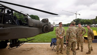 Members of the US Army gather next to an US Army AH-64 Apache helicopter on display on the National Mall during the Army 250th Anniversary Parade in Washington, DC on June 14, 2025. Image- AFP