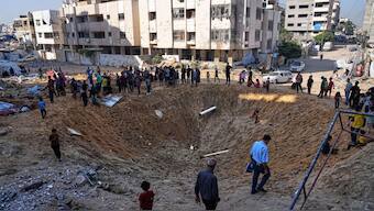 Palestinians gather around a crater caused by an Israeli strike on a displacement tent camp in Gaza City, June 28, 2025. (AP Photo)