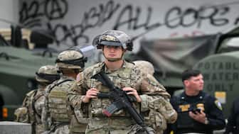 Members of the California National Guard stand watch outside the Edward R. Roybal Federal Building on Tuesday, following another day of protests in response to federal immigration operations in Los Angeles. AFP