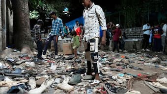 People rummage through footwear strewn outside M. Chinnaswamy Stadium after a stampede caused by frenzied fans celebrating Royal Challengers Bengaluru's victory in the Indian Premier League cricket tournament, in Bengaluru, June 4, 2025. AP