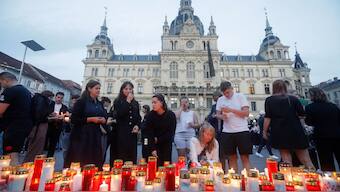 People light candles at a makeshift memorial site after several people died in a school shooting, on June 10, 2025 in Graz, southeastern Austria. AFP