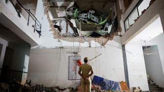 A police officer stands in front of the wreckage of an Air India aircraft, bound for London's Gatwick Airport, which crashed during take-off from an airport in Ahmedabad, June 12, 2025. Reuters