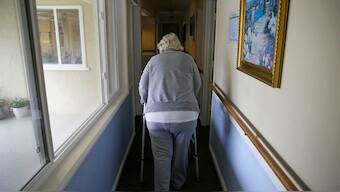 FILE - A woman uses a walker as she heads to her room at a senior care home in Calistoga, Calif., on Dec. 5, 2019. AP