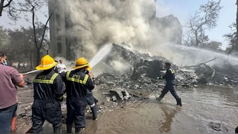 Rescue team members work as smoke rises at the site where an Air India plane crashed in Ahmedabad, India, on June 12, 2025. Reuters
