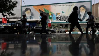 People walk next to a mural with a picture of Iran's Supreme Leader, Ayatollah Ali Khamenei, on a street in Tehran, Iran. Reuters