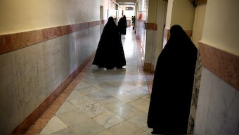 Female prison guards walk along a corridor in Tehran's Evin prison June 13, 2006. Reuters