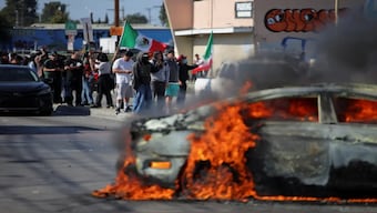 Protesters in Paramount, California, near a burning car as feds clash with rioters. Reuters
