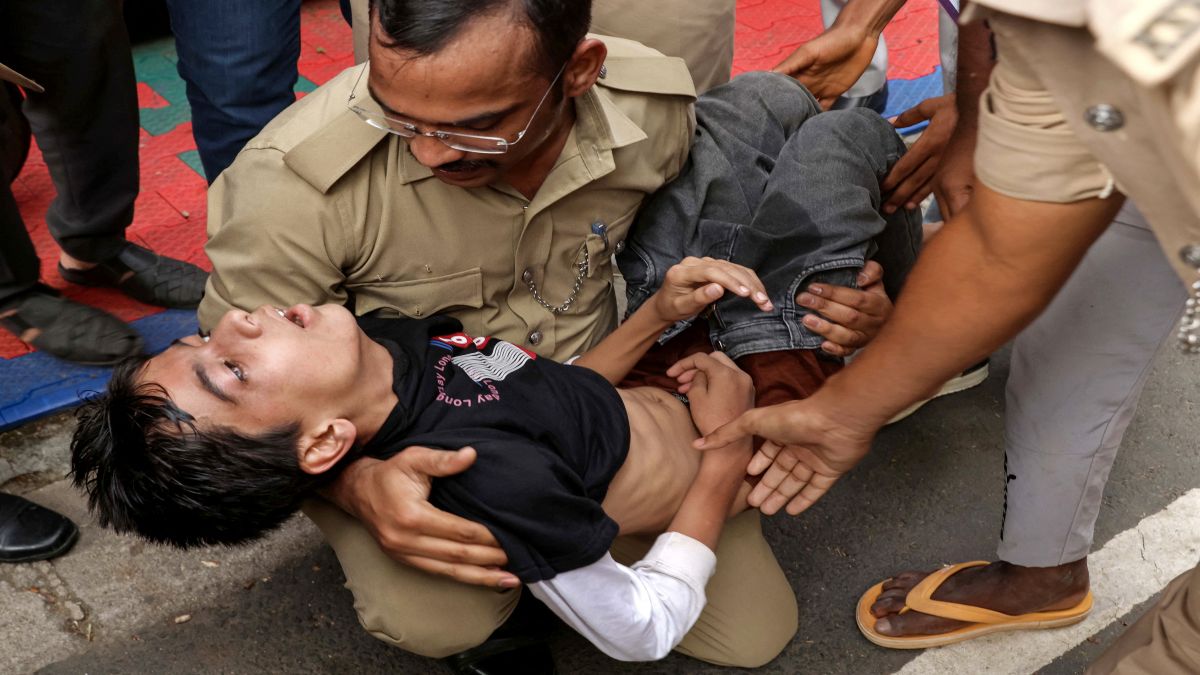 Police personnel assist a stampede victim as he gasps to breathe. Image: AFP Police personnel assist a stampede victim as he gasps to breathe. Image: AFP