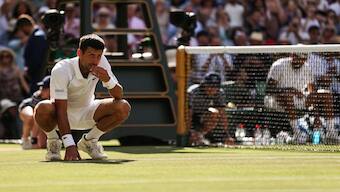 Novak Djokovic eats a blade of grass from Centre Court court after defeating Nick Kyrgios during their men's singles final tennis match at the 2022 Wimbledon Championships at The All England Tennis Club in Wimbledon. File image/AFP