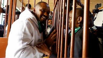Kenyan human rights activist Boniface Mwangi talks to his wife Njeri Mwangi from a steel caged dock after he was charged with unlawful possession of ammunition over his alleged role in deadly anti-government protests in June, at the Kahawa Law Courts in Kiambu County, Kenya July 21, 2025. Reuters