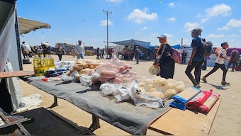 Palestinians look at foodstuffs for sale at a makeshift market in the Mawasi area of Rafah, amid a huge spike in prices of already scarce foodstuffs in the Israel-besieged Gaza Strip on July 20, 2025. AFP