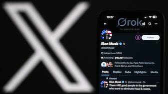 An illustration photograph taken on February 20, 2025 shows the X account of Elon Musk displayed on a phone screen next to the X logo displayed on a laptop screen, in a residential property in Guildford, south of London. AFP