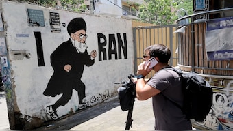 People walk past a mural drawn by the "Grafitiyul" graffiti art group depicting Iran's Supreme Leader Ayatollah Ali Khamenei, on a street in the Israeli coastal city of Tel Aviv on July 22, 2025.  AFP