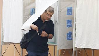 A voter leaves a booth during voting for the recall election at a polling station in Taipei. AFP