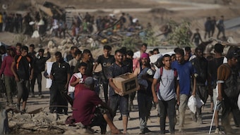 Palestinians carry humanitarian aid packages near the Gaza Humanitarian Foundation distribution center operated by the U.S.-backed organization in Khan Younis, southern Gaza Strip. AP