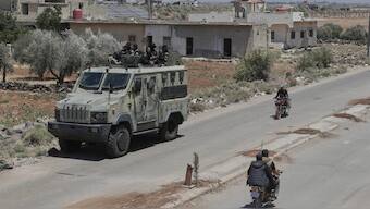 Syrian government security forces sit on their armored vehicle at Busra al-Harir village in Daraa, as they prepare to enter Sweida province where clashes erupted between Druze militias and Sunni Bedouin clans, southern Syria. AP
