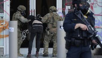 US Customs and Border Protection agents detain a man outside the US Immigration and Customs building during a protest in Portland, Ore. File image/ AP