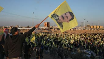 Syrian Kurds hold flags as they gather after Turkey's jailed militant leader Abdullah Ocalan called on his Kurdistan Workers Party (PKK) to lay down its arms on Thursday, a move that could end its 40-year conflict with Ankara and have far-reaching political and security consequences for the region, in Hasakah, Syria February 27, 2025. REUTERS/Orhan Qereman/File Photo