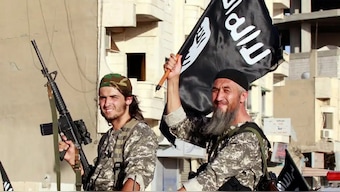 The undated photograph shows an Islamic State (Isis) terrorist holding a gun and another holding the group's flag. (Representative Photograph, Credit: Reuters) 