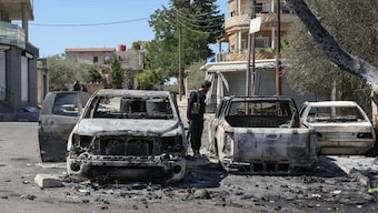 A member of Syrian security forces looks at burnt vehicles amid ongoing clashes in the southern city of Sweida on July 16, 2025. Syrian regime of Ahmed al-Sharaa deployed troops in the predominantly Druze province of Sweida after clashes between Druze fighters and Bedouin tribes killed scores of people. (Photo: Bakr ALkasem/ AFP)