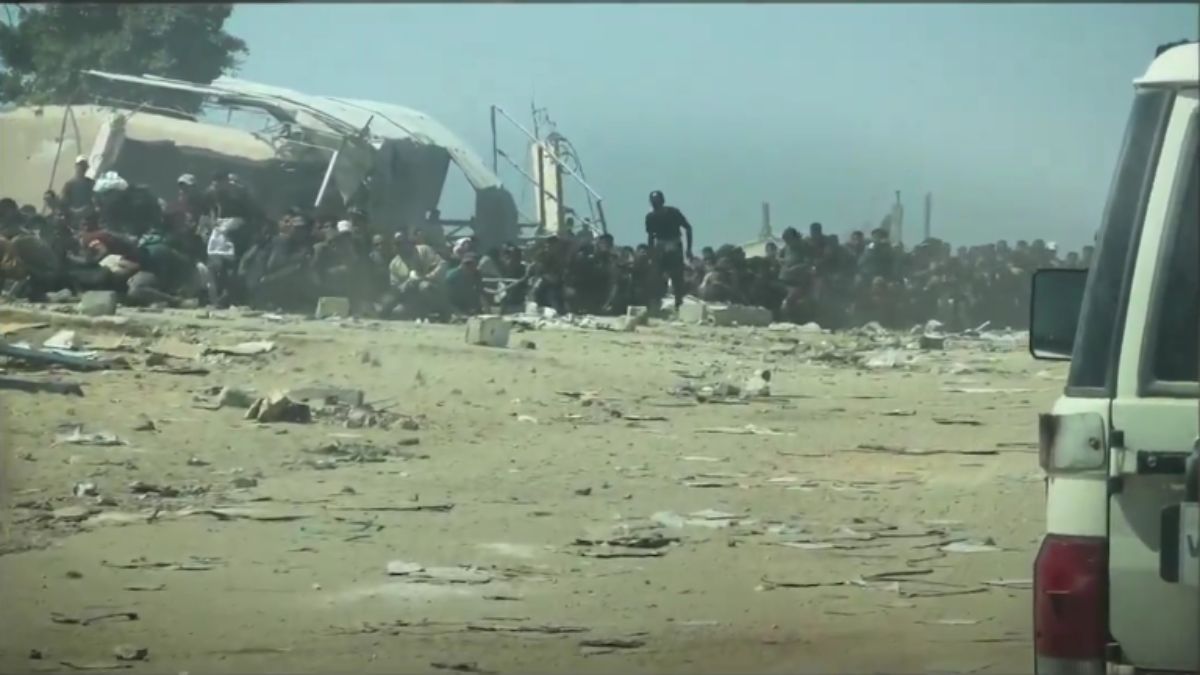 In this screengrab from a video shared by the United Nations (UN), Palestinians are seen sitting as a UN convoy with food supplies approaches them in the Gaza Strip. The UN said Israeli bullets were landing merely inches away from these people. (Photo: UN's Office for the Coordination of Humanitarian Affairs) In this screengrab from a video shared by the United Nations (UN), Palestinians are seen sitting as a UN convoy with food supplies approaches them in the Gaza Strip. The UN said Israeli bullets were landing merely inches away from these people. (Photo: UN's Office for the Coordination of Humanitarian Affairs)
