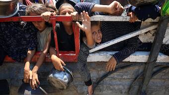 Palestinian children gather to receive food from a charity kitchen, amid a hunger crisis, in Gaza City, July 22, 2025. File Image/Reuters