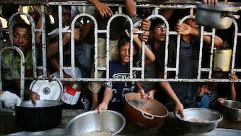 Palestinian children wait for a meal at a charity kitchen in the Mawasi area of Khan Yunis in the southern Gaza Strip on July 22, 2025.  Image- AFP