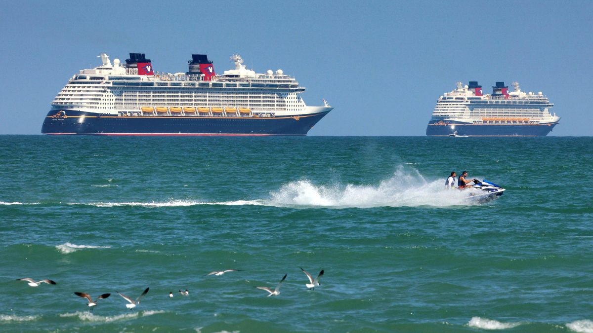 FILE - Jet skiers pass the Disney Cruise Line ships "Fantasy," left, and "Dream" on the horizon as they sit stationary off of Cocoa Beach, Fla., in this view from Lori Wilson Park, March 24, 2021. AP FILE - Jet skiers pass the Disney Cruise Line ships "Fantasy," left, and "Dream" on the horizon as they sit stationary off of Cocoa Beach, Fla., in this view from Lori Wilson Park, March 24, 2021. AP