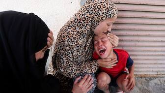 A Palestinian woman comforts a child as casualties are brought into Al-Aqsa Martyrs Hospital following an Israeli strike, in Deir al-Balah, central Gaza Strip, July 10, 2025. REUTERS