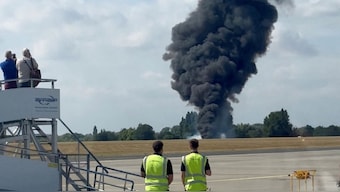 A plume of black smoke rises from an area near the runway after a small plane crash, as seen from inside a building at London Southend Airport, in Southend, Britain, July 13, 2025, in this screen grab obtained from a social media video. @agussromagnoli via X/via Reuters