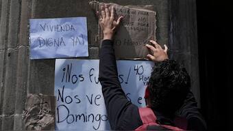 A demonstrator hangs signs against gentrification outside a news conference by Mexico City Mayor Clara Brugada on regulating rental housing prices at the city government house in Mexico City, Wednesday, July 16, 2025. AP