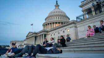 Senate staffers rest on the US Capitol steps at sunrise on Capitol Hill. (Photo: Reuters)