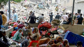 Families wait amidst the debris of a collapsed building in Karachi on July 5, 2025. Source: AFP
