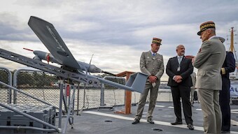 French Army Brigadier General General Eric Ozanne (L) stands with Commander of French Forces New Caledonia Major General Yann Latil (R) and French Ambassador to Australia Pierre-André Imbert (C) next to a drone aboard the French patrol vessel Auguste Benebig, which will participate in the annual Talisman Sabre exercise, in Sydney on July 13, 2025. Source: AFP