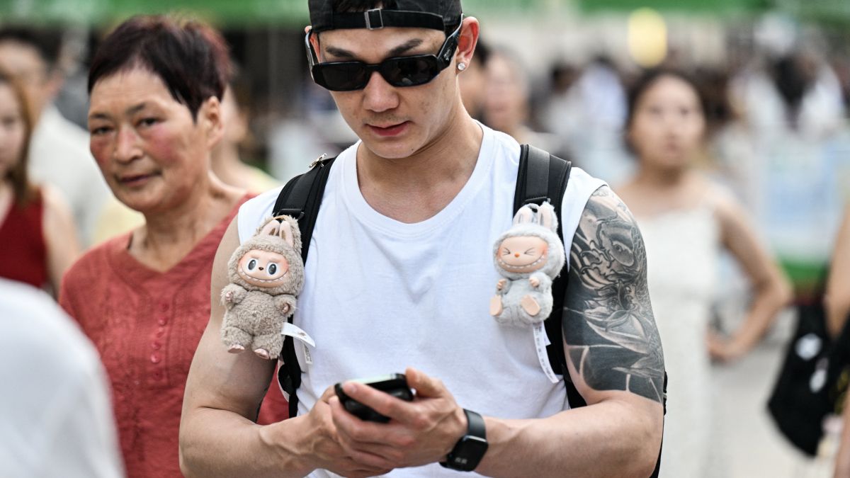 A man walks with two Labubu plush toys hanging from his backpack straps along a pedestrian street on The Bund in Shanghai. The toys are a hit and now fake versions, Lafufu, have flooded the market. AFP A man walks with two Labubu plush toys hanging from his backpack straps along a pedestrian street on The Bund in Shanghai. The toys are a hit and now fake versions, Lafufu, have flooded the market. AFP