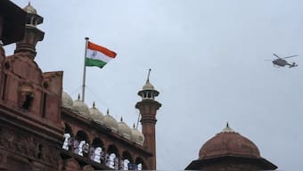 A military helicopter approaches to shower flower petals after the national flag was unfurled at the rampart of the Red Fort, during rehearsal for Independence Day celebrations, in New Delhi. PTI