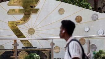 A man walks past an installation of the Rupee logo and Indian currency coins outside the Reserve Bank of India (RBI) headquarters in Mumbai, India. File image/ Reuters