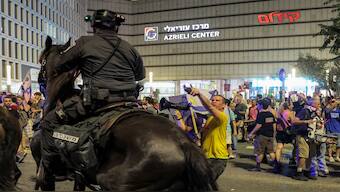  A protester confronts a mounted Israeli policeman attempting to disperse people gathered for a demonstration organised by the families of the Israeli hostages taken captive in the Gaza Strip since the October 2023 calling for action to secure their release, by Azrieli Centre outside the Defence Ministry headquarters in Tel Aviv on August 9, 2025. AFP