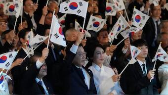 South Korean President Lee Jae Myung (C) and his wife Kim Hye-kyung (center-R) wave national flags during the 80th anniversary of Korea’s liberation from Japanese colonial rule, in Seoul on August 15, 2025. AFP